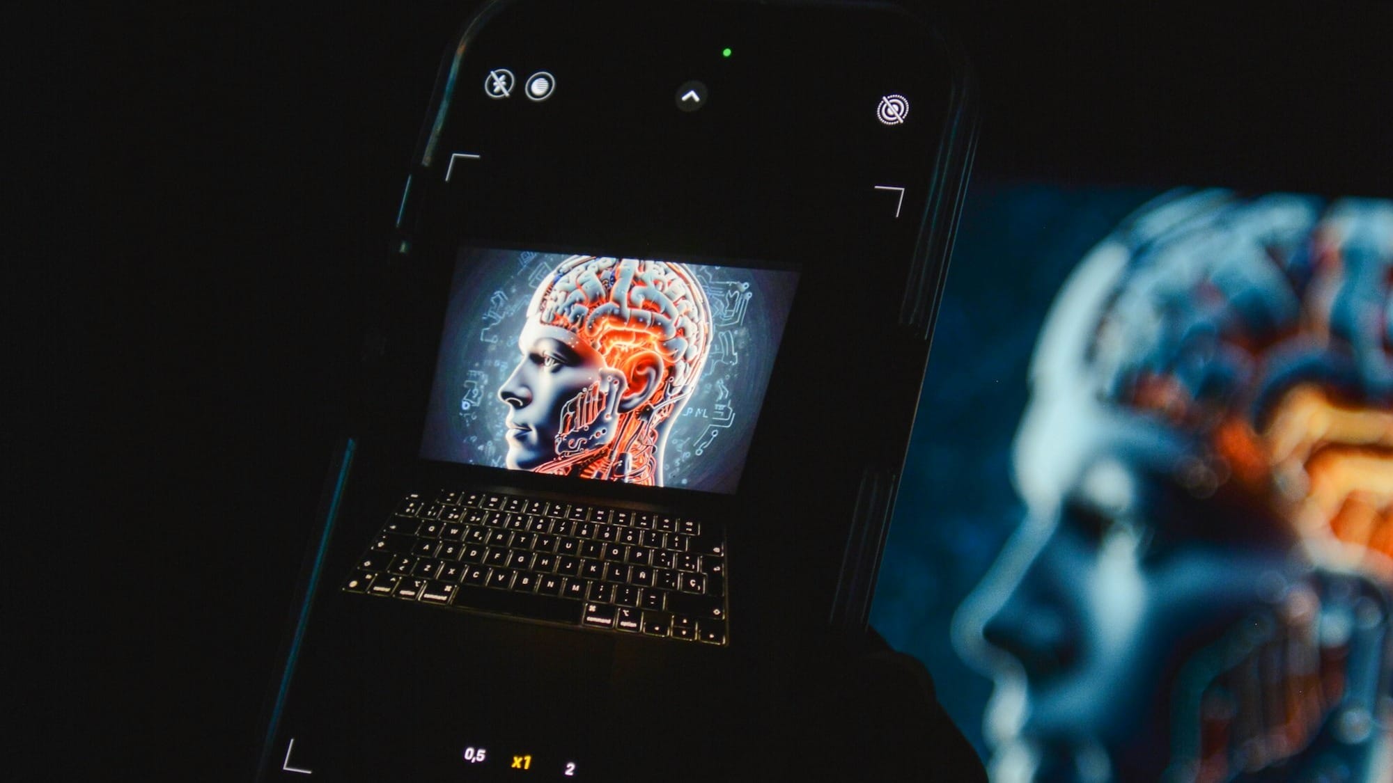 a cell phone sitting on top of a laptop computer